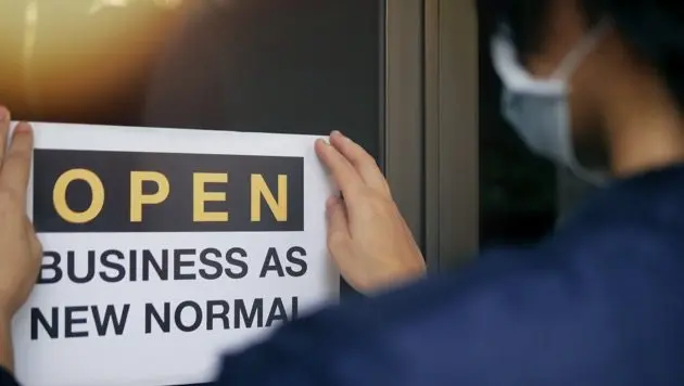 reopening-for-business-adapt-to-new-normal-in-the-novel-coronavirus-covid-19-pandemic-rear-view-of-business-owner-wearing-medical-mask-placing-open-sign-open-business-as-new-normal-on-front-door