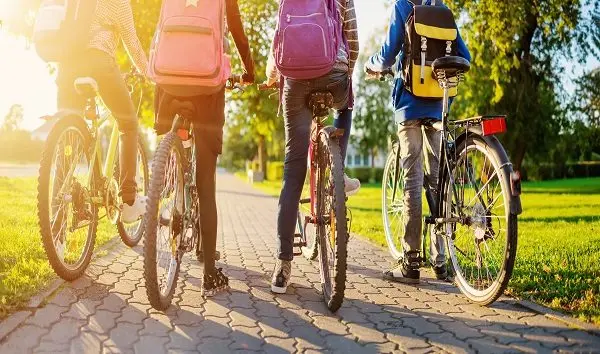 children-with-rucksacks-riding-on-bikes-in-the-park-near-school-3