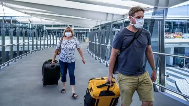senior-woman-and-adult-son-wearing-face-mask-at-airport-in-fear-of-coronavirus-and-travel-ban-and-international-trips-cancellations-for-disease-control-and-prevention-of-covid-19-outbreak-pandemic