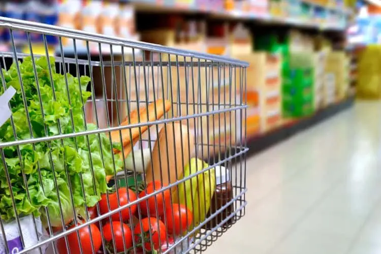 shopping-cart-full-of-food-in-supermarket-aisle-side-tilt