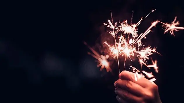 hand-holding-burning-sparkler-blast-on-a-black-bokeh-background-at-nightholiday-celebration-event-partydark-vintage-tone