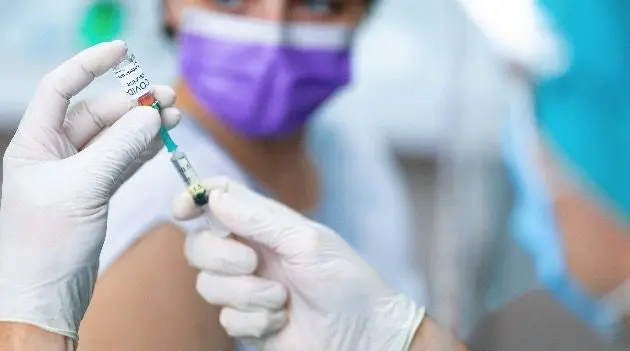 doctors-hands-in-surgical-gloves-preparing-covid-19-vaccine-for-female-patient