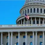 Close-up of the United States flag in front of the Capitol Building's dome in the morning^ Washington^ D.C.