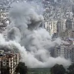 Large plumes of grey smoke billow from mult story apartment buildings following an explosion in a densely populated city^ depicting the devastation of modern urban warfare. Jan 28 2026 in USA