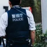 Japanese police squad formation in protective uniform with "Police" logo^ policemen patrol maintain public during political demonstration protest rally in the streets of Tokyo city center^ Japan