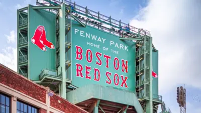 Vew of the historic architecture of the Famous Fenway Park Stadium in Boston^ MA^ USA showcasing its huge sign^ old brick walls^ and entrances on Lansdowne street. Boston^ MA^ USA - March 1^ 2023
