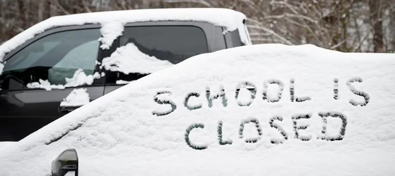 school is closed written in snow on a car window