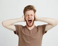 portrait-young-emotive-angry-man-closing-ears-shouting-screaming-scaled721775
