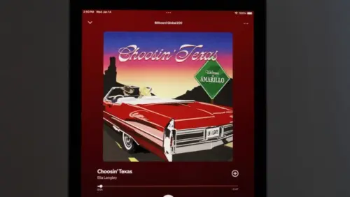 An Apple iPad displays the Spotify music streaming application^ which is playing the song "Choosin' Texas" by the artist Ella Langley