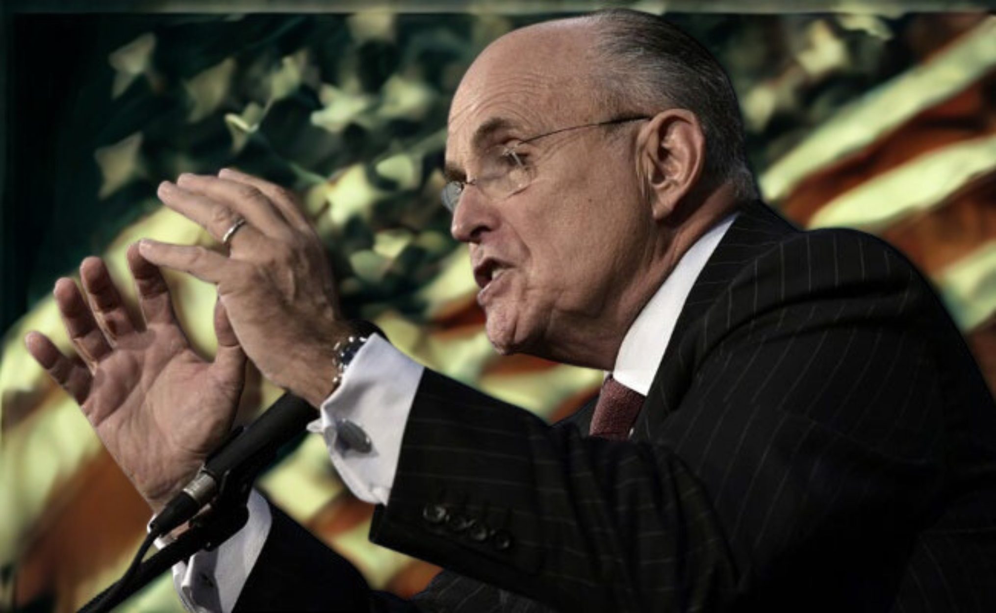 Rudolph W. Giuliani speaking at a public address with an American flag in the background