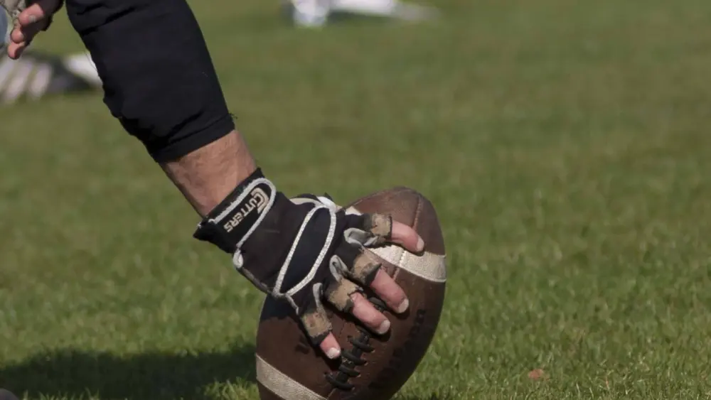 football-player-holding-football-on-grass-generic-e1459896025823