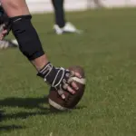 football-player-holding-football-on-grass-generic-e1459896025823