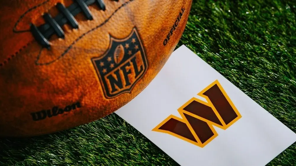 Washington Commanders NFL team Logo and American football ball on Green Grass. WASHINGTON^ USA^ FEBRUARY 10^ 2025