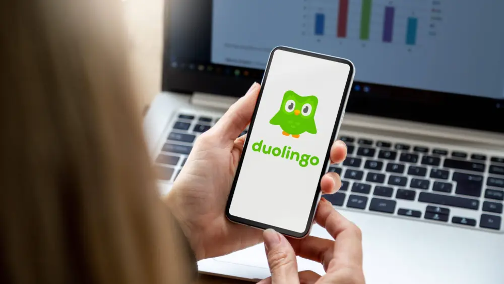 businesswomaninherofficeholdingasmartphonewithduolingo