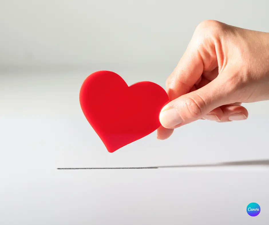 Hand holding a red paper heart.