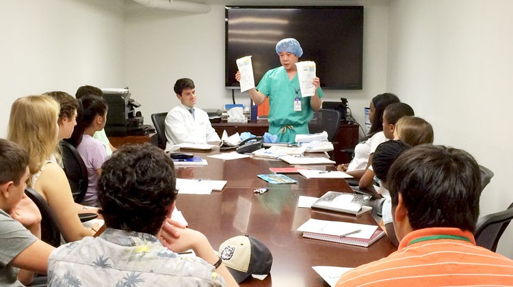 Lecture on operating room environment and scrub workshop with Dr. Sean Peden (seated) and Ray Delacruz, Education Specialist.