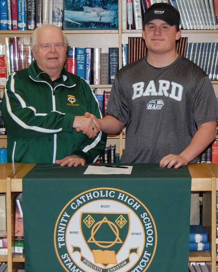 Trinity Catholic High School Athletic Director and Head Baseball Coach Tracy Nichols congratulates senior Dillon Daine after he signed his National Letter of Intent to play baseball at Bard College (Contributed Photo)