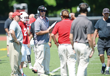 Head coach John Marinelli chats with his coaching staff during Saturday’s scrimmage at GHS. (John Ferris Robben photo)