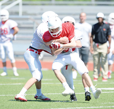 Members of the white team apply the tackle during Saturday’s scrimmage. (John Ferris Robben photo)
