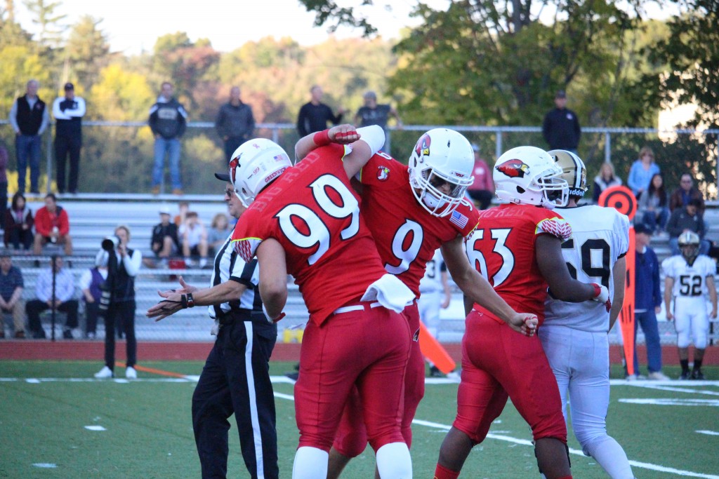 Greenwich's Sam Colandro and Ian Pearson celebrate after recording a sack against Trumbull in Saturday's 42-32 win (Evan Triantafilidis photo)