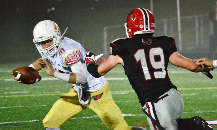 Greenwich High School quarterback Connor Langan gets chased down by a New Canaan defender during Friday night's game against FCIAC foe New Canaan High School. (Paul Silverfarb photo)