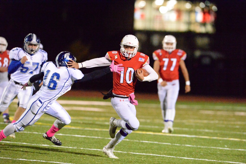 Greenwich senior quarterback Connor Langan stiff arms a defender in Friday's game against Fairfield Ludlowe (John Ferris Robben photo)