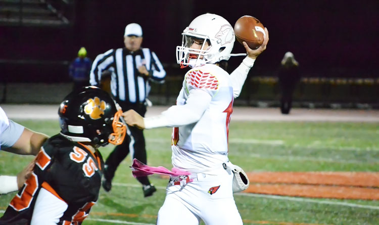 Greenwich High School's Connor Langan throws the completion for a touchdown just behind getting taken down during Friday night's game against Ridgefield. (Paul Silverfarb photo)