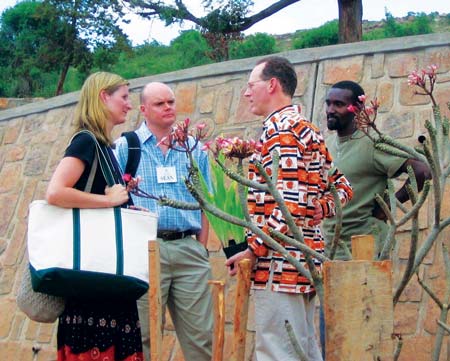 Lesley King in the field in Rwanda, talking of the Rwinkwavu Hospital expansion with Partners in Health co-founder Dr. Paul Farmer, on right, and Trinity Church member Sean Cassidy, and, right rear, Bruce Nizeye, head of construction for Partners in Health in Rwanda. (contributed photo)