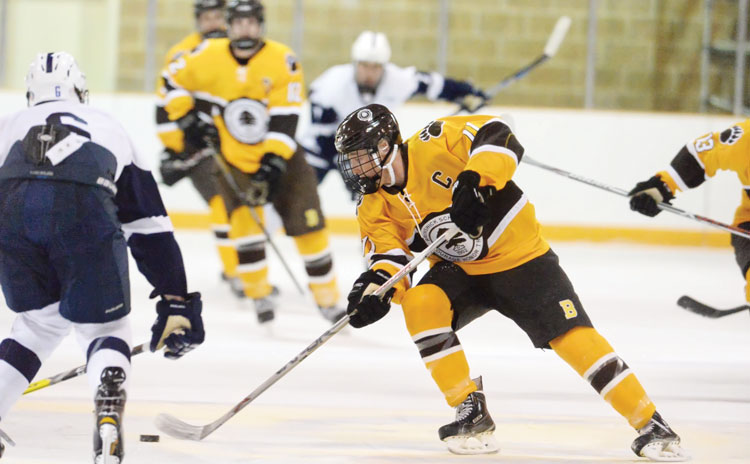Brunswick School junior captain Christian LeSueur works the puck past the Hotchkiss School defense during a recent game at the Hartong Rink. This weekend, the Bruins will look to continue its playoff push during competition at the Empire Cup. (John Ferris Robben photo)