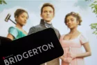 The logo of the new Netflix series "Bridgerton" on the display of a smartphone in front of the TV