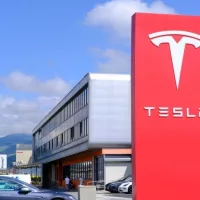 Tesla office^ American company^ electric car manufacturer Elon Musk^ company logo on red stand^ alternative energy development concept^ electric vehicle production^ Innsbruck^ Austria - June 2022