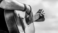 Acoustic guitars playing. Music concept. Black and white. Male musician playing guitar^ music instrument. Man's hands playing acoustic guitar^ close up.
