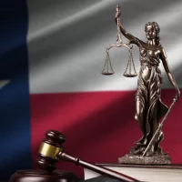 Texas US state flag with statue of lady justice^ constitution and judge hammer on black drapery.