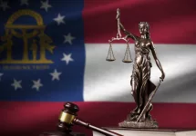 Georgia US state flag with statue of lady justice^ constitution and judge hammer on black drapery