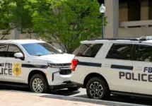 Police patrol cars used by the FBI parked on a street outside the J Edgar Hoover headquarters building in downtown Washington DC. Washington DC^ USA - 30 April 2024