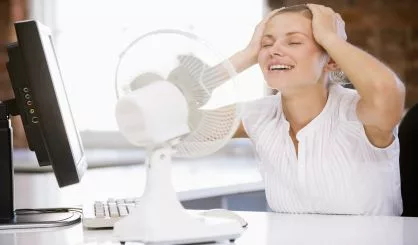 businesswoman-in-office-with-computer-and-fan-cooling-off