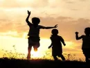 children-running-on-meadow-at-sunset