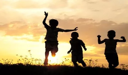 children-running-on-meadow-at-sunset