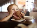 little-child-having-lunch-with-sandwich-and-tea-in-cafe