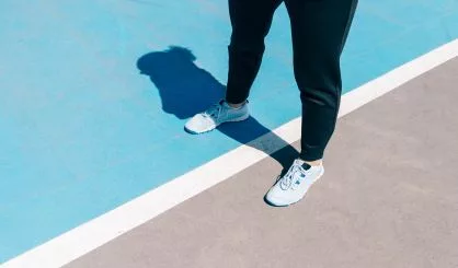 cropped-image-of-female-legs-in-sneakers-and-black-pants-standin