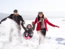 father-and-mother-with-their-daughter-playing-in-the-snow