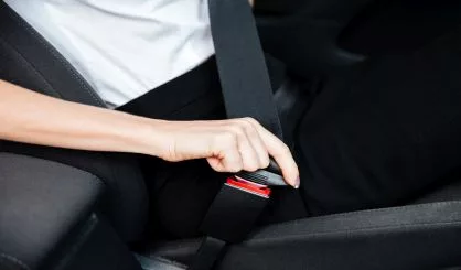 woman-sitting-in-car-and-putting-on-her-seat-belt