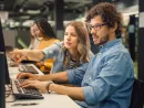 university-library-bright-caucasian-girl-and-smart-boy-together-work-on-computers-chat-discuss-class-assignment-explain-and-advice-each-other-diverse-group-of-students-exam-study-teamwork