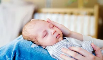 unrecognizable-mother-with-newborn-baby-son-sitting-on-bed