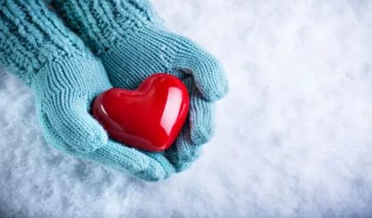 woman-hands-in-light-teal-knitted-mittens-are-holding-a-beautifu