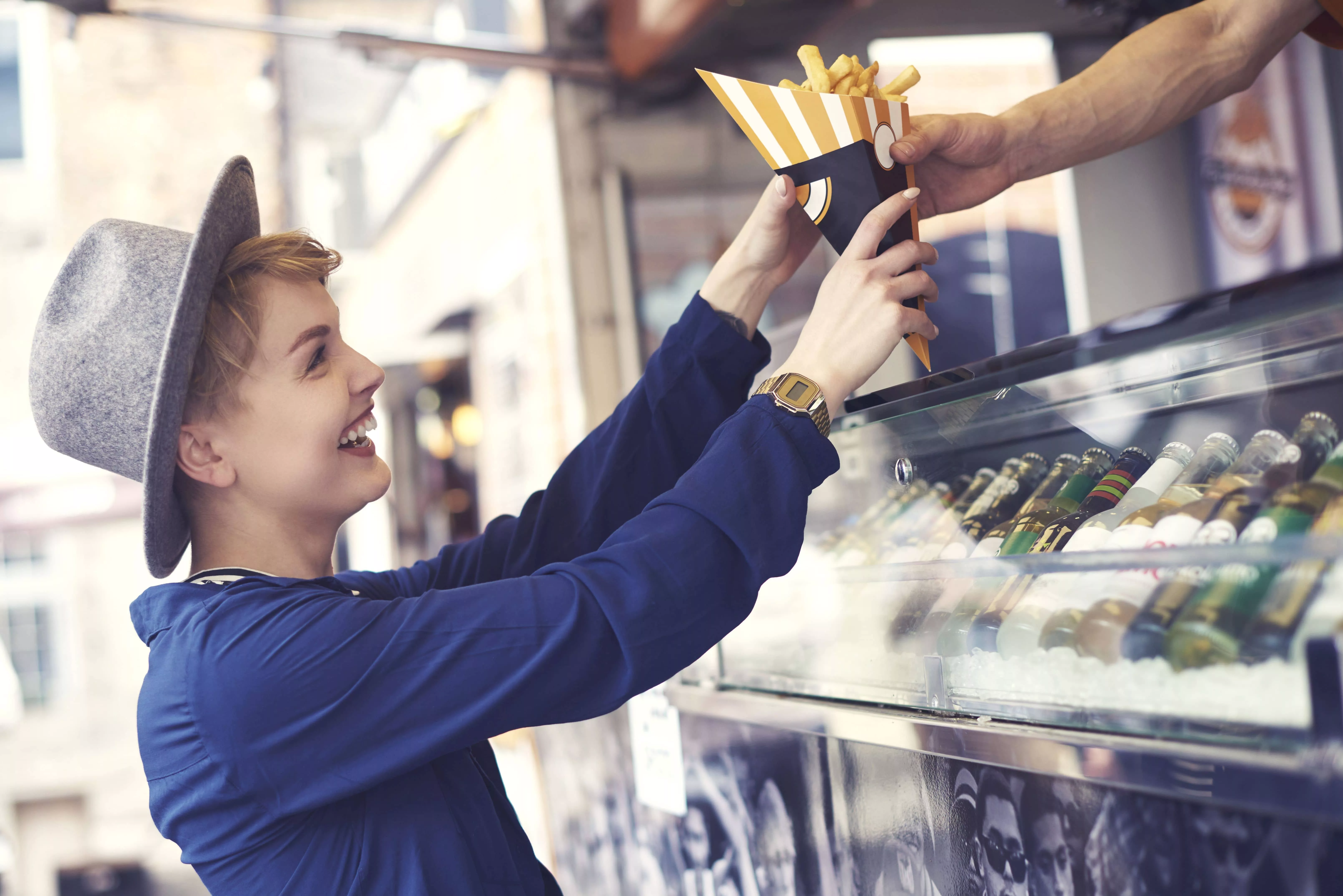 female-customer-reaching-food-from-vendor