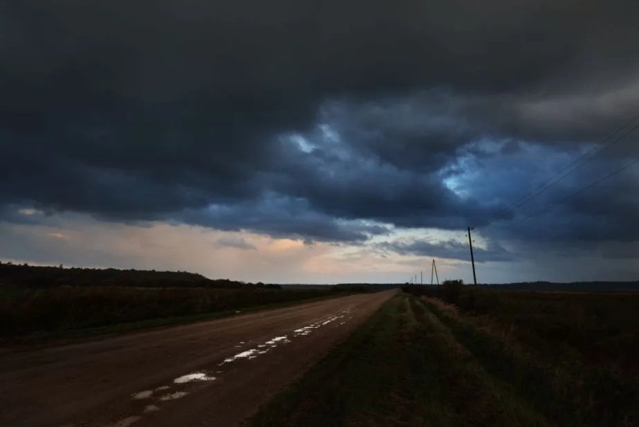 road-in-the-field-and-the-dark-dramatic-rain-clouds-autumn-in-latvia