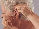 mature-woman-inserting-a-hearing-aid-in-her-ear