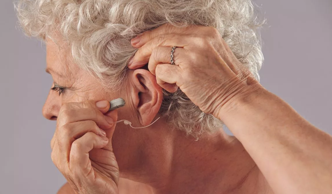 mature-woman-inserting-a-hearing-aid-in-her-ear