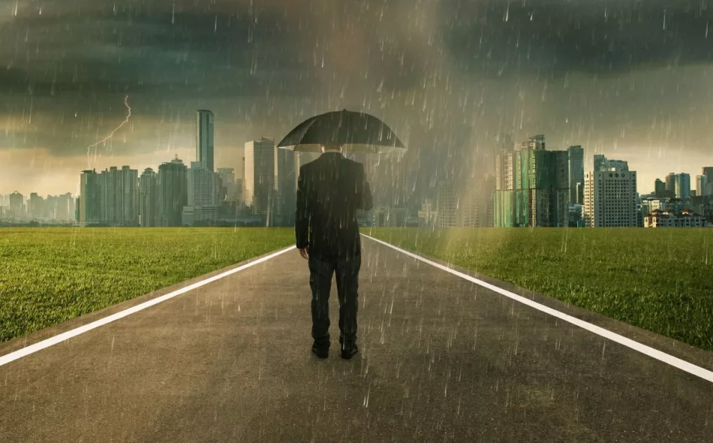 businessman-below-storm-rain-with-umbrella-risk-and-crisis-concept